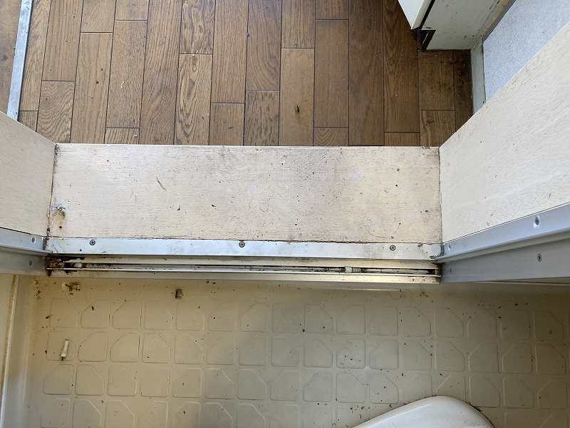 古い浴室ドアの下の枠。長く使われて汚れが目立っていた