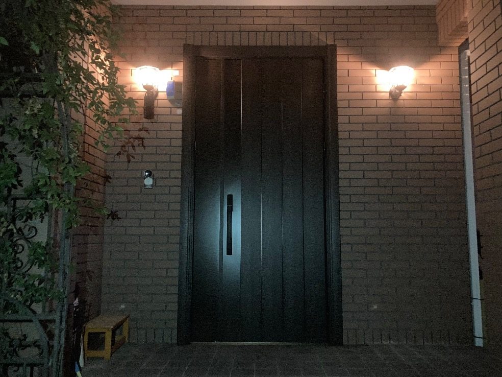 福岡市城南区のお宅で、れんがの外壁に濃い色の親子ドアを付けたあと