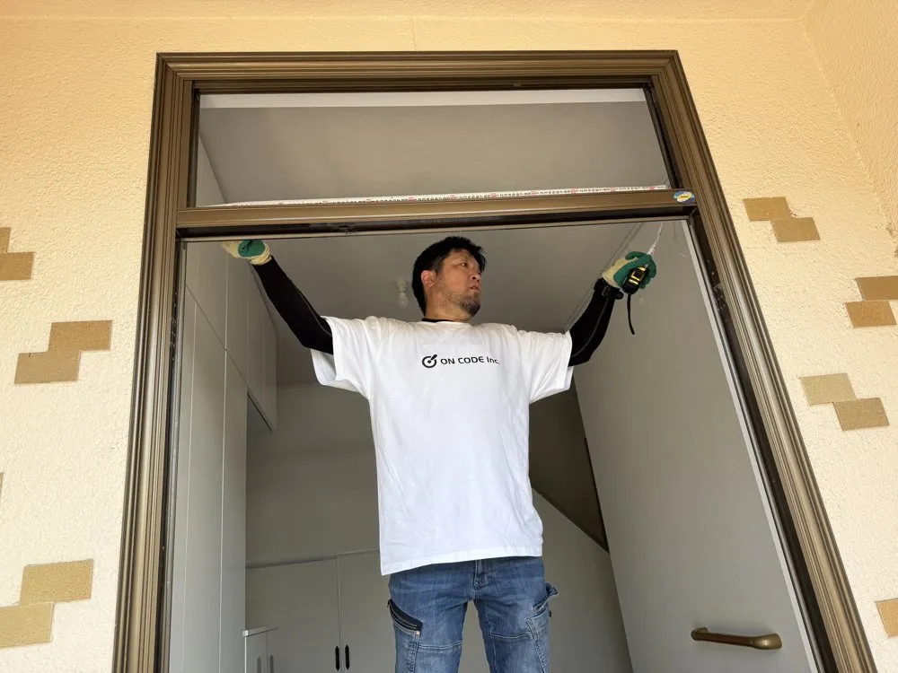 玄関の枠の大きさを確かめるスタッフ