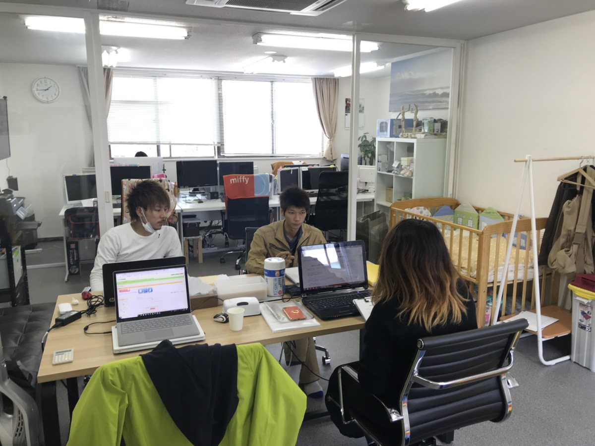 事務所で相談の写真を見て見積りをつくるスタッフ